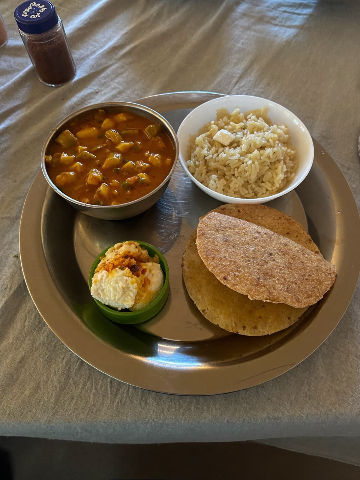 Thali indiano com dal makhani, rotis e arroz em mesa de família